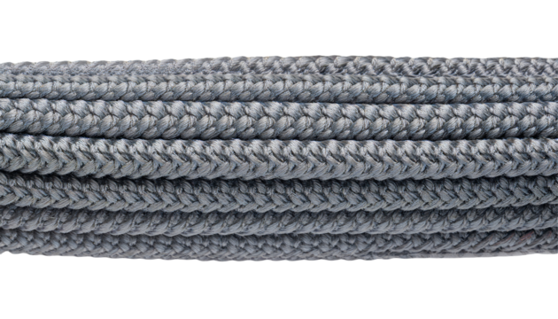 stacked coils of grey braided paracord rope with dense woven texture and synthetic strands for industrial or survival use on isolated background
