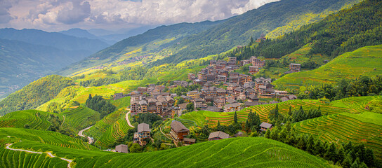 The village surrounded by lush green rice fields in Longji rice terraces, Guangxi province, China
