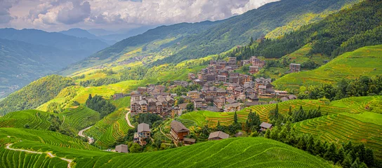 Fotobehang Rijstvelden The village surrounded by lush green rice fields in Longji rice terraces, Guangxi province, China  © Tatiana Kashko