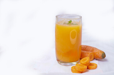Glass of fresh carrot juice and carrot slices with mint leaves on the white background. detox drink helps weight loss,,healthy lifestyle and vegetarian nutrition food and drink concept,
