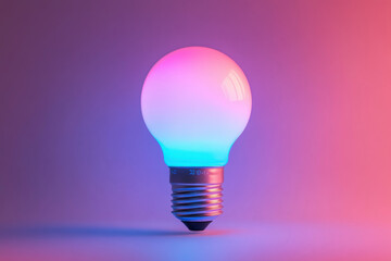 Light bulb emitting pink and blue hues, standing out in darkness, creative concept or symbol of ideas and inspiration.
