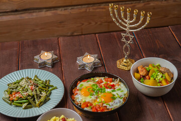 Set table, Jewish food, tzimmes, chelnt, shakshuka and couscous with dried fruits