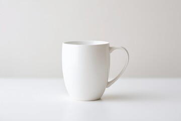 Obraz premium solitary coffee mug stands on plain white surface illuminated by soft light emphasizing its contours