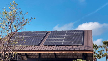 Naklejka premium Solar Panels on Roof with Clear Blue Sky