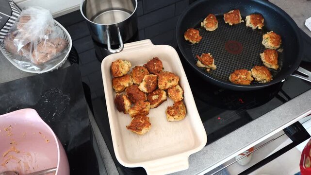Stockholm, Sweden A cook fries Danish fish cakes, or Fiskefrikadeller, in oil over an induction stove.