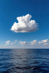 Fototapeta premium A singular fluffy cloud over a silky blue ocean and sunny day