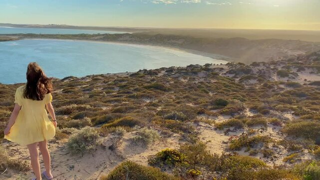 girl stands and admires long sandy beach between west cape lookout and Ethel Wreck Beach with powerful waves. Dhilba Guuranda-Innes National Park, Yorke Peninsula, south australia