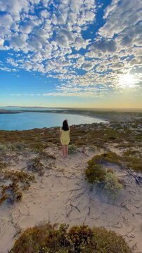 girl stands and admires long sandy beach between west cape lookout and Ethel Wreck Beach with powerful waves. Dhilba Guuranda-Innes National Park, Yorke Peninsula, south australia