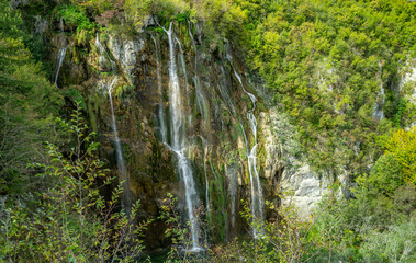 Waterfall in the Plitvice Lakes in Croatia. The waterfalls in forest. Summer view of beautiful waterfalls and clear lake. Plitvice Lakes National Park, Croatia. Summer nature landscape.