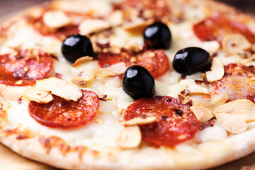 Pizza with salami and mozzarella cheese. Wooden background. Soft focus. Close up.	