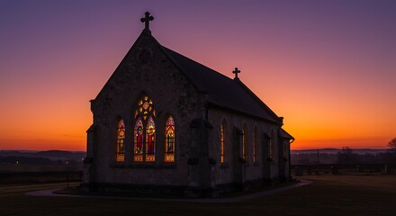Fototapeta premium Stone Church at Sunset: Glowing Stained Glass and Serene Silhouette