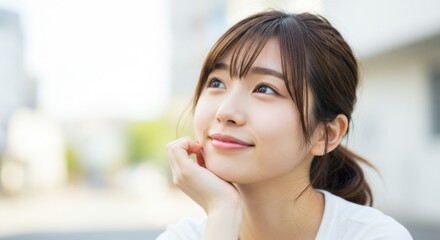 Dreamy young Japanese woman looking up in contemplation