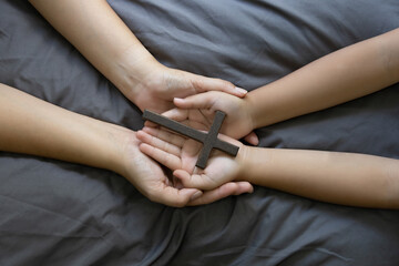 Cross hands palms wood holding religion faith christian symbol together. faith, christian symbol together spirituality devotion prayer hope devotion worship hand closeup