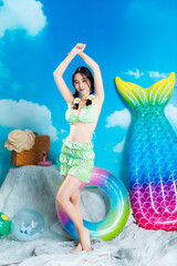 Cheerful Asian Girl Posing with Arms Crossed Overhead in Green Ruffle Bikini