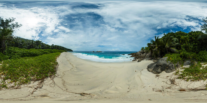 A serene beach landscape with turquoise waters, fine sand, and dense greenery lining the shores. Anse Petit Boileau, Seychelles. Monoscopic image.