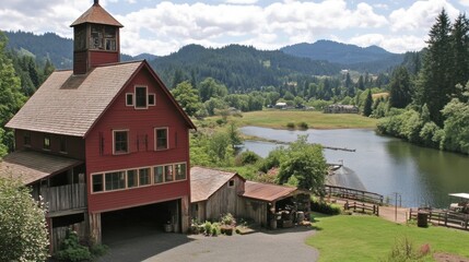 Obraz premium Malowniczy widok na czerwoną stodołę nad spokojną rzeką, góry i bujną zieleń w tle
