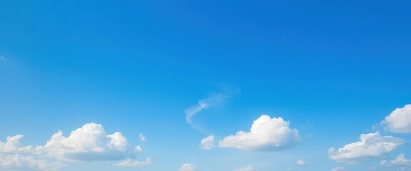 Fototapeta premium Soft white clouds drift across a gradient blue sky, transitioning from deep to light blue hues, heavens, nature