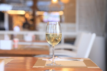 a glass of cold white wine and serving in the restaurant
