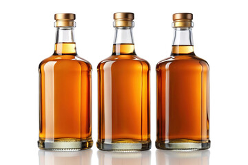 Three amber colored liquor bottles with golden caps arranged in a row