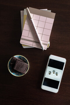 journal book with chocolate and mobile phone