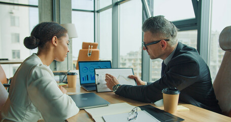 Businessman showing financial chart to colleague