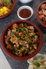Delicious chicken karaage donburi with sesame seeds and spring onions in brown bowl