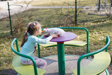 Fototapeta premium Girl Kissing Toy Duck at Playground