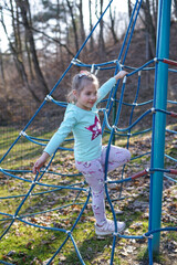 Girl Climbing Rope Net at Playground