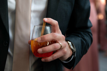 Groom Holding Signature Cocktail at Coastal Wedding Reception
