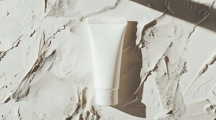 A white tube of cream on a textured white surface with shadows creating a minimalist aesthetic look