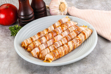Raw sausages wrapped in bacon