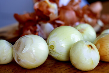 A peeled onion lying on the kitchen table. Onions are a vegetable rich in nutrients and trace...