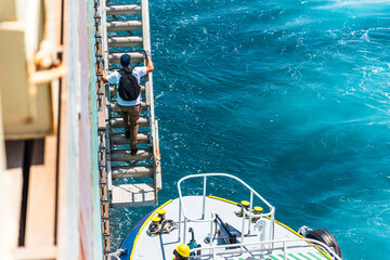 Navigational pilot entering cargo ship using pilot gangway, he will ensure safety maneuvering when...