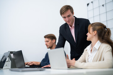 Business collaboration occurs in a modern office setting with professionals engaged in discussion and work