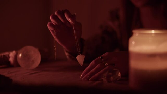 Pendulum divination during candlelit tarot session