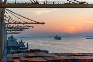 Beautiful sunset silhouette of ships and gantry cranes in the port of Jebel Ali. Golden hour in the...