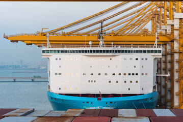Large cargo container ship berthed under gantry cranes in the port of Jebel Ali container terminal,...