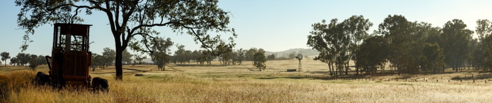 Farm panorama with grader and windmill.