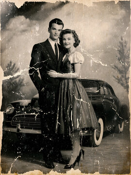 Vintage black and white photo of a 1940s couple posing in front of a classic car, retro fashion and romantic atmosphere, nostalgic cinematic scene with timeless elegance, damaged photo.
