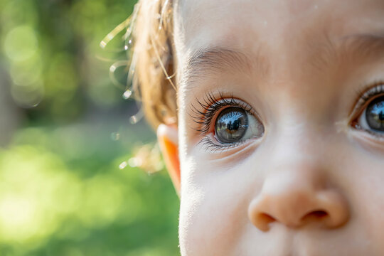 Child’s innocent eye, wide and curious, soft sunlight reflection, heartwarming realism