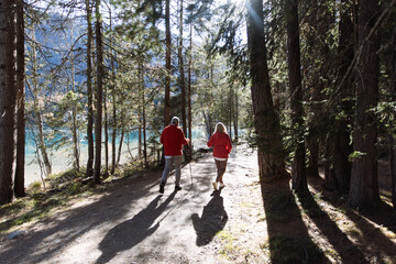 Senior couple walking forest path by Lago di Anterselva
