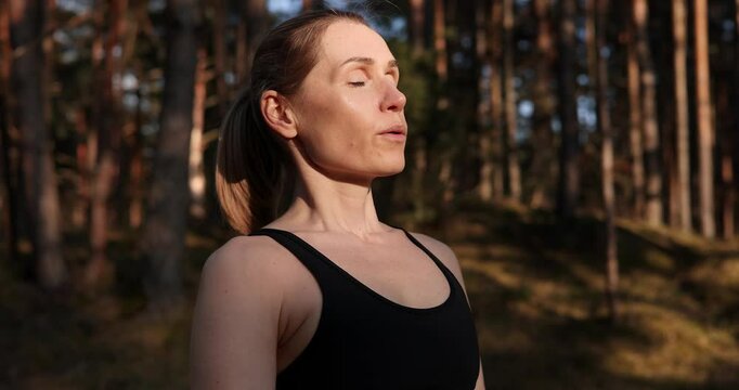 breathwork. woman taking deep breath of fresh air meditating in forest. practicing yoga in nature. mental health and stress relieve concept