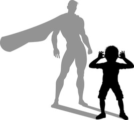 A superhero child or kid boy revealed by his shadow silhouette as a super hero in a cape.