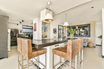 Bright and spacious modern kitchen featuring a sleek dining area with comfortable seating and stylish decor, creating a welcoming atmosphere.