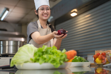 A female chef broadcasts her cooking knowledge live on a social media app on her mobile phone.