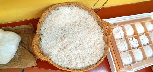 Rock white salt in a wicker basket. Salt and mineral extraction. Pink salt. Salt mine. Antique tools.