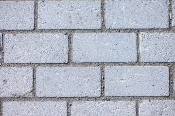 Interlocking gray concrete brick pavers forming a solid, textured pavement surface, providing versatility for various outdoor applications like walkways, patios, and driveways