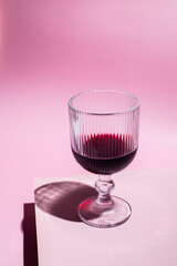 glass of wine on pink background