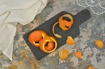 Orange or tangerine peel on kitchen table. Bio-waste segregation: where to throw away peelings to...