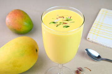 Serving mango lassi in a glass cup.